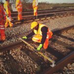 Member of Apprentice Council Ade on a train track in hi-vis at work